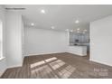 Open concept living room leading to kitchen, featuring wood-look floors at 483 Shasta St # 5202, Gastonia, NC 28052