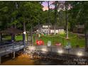Waterfront backyard featuring a dock with gazebo, string lights, chairs, and swing facing the lake at 570 Blue Heron Rd, Salisbury, NC 28146