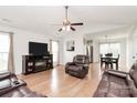 Bright living room featuring hardwood floors, a ceiling fan, and a cozy fireplace with TV at 5804 Fairchase Ave, Charlotte, NC 28269