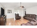 Spacious living room with hardwood floors, modern ceiling fan, and comfortable leather seating at 5804 Fairchase Ave, Charlotte, NC 28269