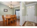 Dining room with hardwood floors, decorative trim, chandelier, and entry door at 5849 Mcclintock Dr # 117, Denver, NC 28037