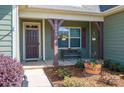 Inviting front porch featuring a bench, hanging plants, and attractive landscaping at 5849 Mcclintock Dr # 117, Denver, NC 28037