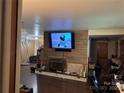 Cozy living room with wood paneling, fireplace, mounted television, and comfortable leather seating and hardwood floors at 703 S Highway 27 Hwy, Stanley, NC 28164