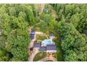 Stunning aerial view of an estate nestled among mature trees, featuring a pool, guest house, and meticulously landscaped grounds at 707 Saint Cloud Dr, Statesville, NC 28625
