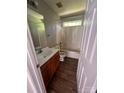 Functional bathroom with wood vanity, shower-tub combo, and updated fixtures at 716 Coy Ct, Charlotte, NC 28216