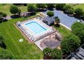 Aerial view of a fenced community pool, playground, and ample green space at 786 Sw Treva Anne Sw Dr, Concord, NC 28027