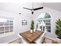 Inviting dining room featuring a wood table, white chairs, a decorative ceiling fan, and a large arched window at 786 Treva Anne Sw Dr, Concord, NC 28027