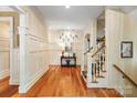 An elegant foyer with hardwood floors, wainscoting, staircase, and stylish decor that create a welcoming entrance at 8534 Highgrove St, Charlotte, NC 28277