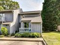 Charming townhome featuring a cozy porch, landscaped garden, and a well-maintained gray wood facade at 100 Willow Run Dr # 26, Gastonia, NC 28056