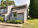 Charming townhome featuring a cozy porch, landscaped garden, and a well-maintained gray wood facade at 100 Willow Run Dr # 26, Gastonia, NC 28056