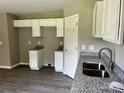 Well-lit kitchen featuring granite counters, white cabinets, and stainless steel sink at 1024 Short St, Salisbury, NC 28144