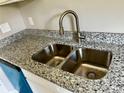 Close-up of a stainless steel double sink with a granite countertop and modern faucet at 1024 Short St, Salisbury, NC 28144