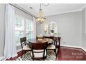 Elegant dining room with a stylish chandelier, round table, and zebra-print rug at 10378 Alexander Martin Ave, Charlotte, NC 28277