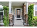 Inviting front porch with stone pillars, black railings, and a stylish front door at 1104 Snowbird Ln, Waxhaw, NC 28173