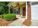 Inviting front porch with a decorative wreath, hanging plants, and a small, well-maintained garden at 1113 Geyser Ct, Fort Mill, SC 29715