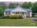 Charming single-story home featuring a vibrant blue front door and tidy landscaping at 120 Mossy Rock Trl, Iron Station, NC 28080