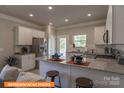 Open kitchen features stainless steel appliances, granite countertops, a center island, and a dining area at 1260 Langston Ln, Salisbury, NC 28144