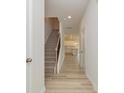 Bright hallway with wood flooring, leading to a staircase and a modern kitchen with white cabinets at 1278 Langston Ln, Salisbury, NC 28144