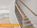 Carpeted stairs with wooden handrail, offering a warm and inviting transition to the next level at 1278 Langston Ln, Salisbury, NC 28144