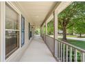 Long covered porch provides ample space and features decorative blue shutters on the exterior windows at 13223 Willow Breeze Ln, Huntersville, NC 28078