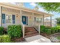 Inviting covered front porch with blue door and matching shutters. Brick stairs add to charm at 13223 Willow Breeze Ln, Huntersville, NC 28078