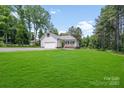 Well-maintained home featuring a detached garage, covered porch, and lush green lawn at 1406 High Shoals Rd, Lincolnton, NC 28092