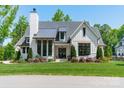 Beautiful exterior featuring a manicured lawn, black-trimmed windows, white board siding and a stylish architectural design at 14228 Ryker Way, Davidson, NC 28036