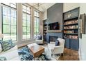 Bright living room with tall windows, custom shelving, and a cozy fireplace, perfect for relaxing and entertaining guests at 14228 Ryker Way, Davidson, NC 28036