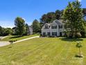 Traditional two-story home with expansive lawn and mature trees creating a serene setting at 148 Spring Grove Dr, Mooresville, NC 28117