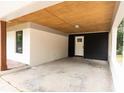 Covered carport showcasing brick and black siding, wood ceiling, a side door, and concrete floor at 1537 Spangler Dr, Shelby, NC 28150