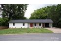 Charming single story home with a red front door, white siding, manicured lawn, and mature trees at 1537 Spangler Dr, Shelby, NC 28150