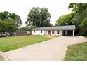 Charming home featuring a vibrant red front door, a well-manicured lawn, and a convenient attached carport at 1537 Spangler Dr, Shelby, NC 28150