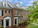 Charming brick townhome featuring manicured landscaping, dormer windows and covered front entry at 16930 Summers Walk Blvd, Davidson, NC 28036