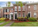Lovely brick townhome with a well-manicured lawn, a decorative front door wreath and black window shutters at 16930 Summers Walk Blvd, Davidson, NC 28036