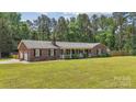 Traditional brick home with an attached garage, a covered front porch and lush green lawn at 1753 Elmwood Dr, Rock Hill, SC 29730