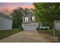 Charming two-story home with a white garage door, black shutters, and a well-manicured lawn at 1835 Allegheny Dr, Gastonia, NC 28054