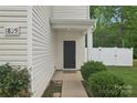Inviting home entrance featuring a black front door, manicured bushes, and white siding at 1835 Allegheny Dr, Gastonia, NC 28054