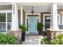 Inviting front porch featuring stone accents, light blue door, and lush potted ferns at 2007 Bishops Ct, Cornelius, NC 28031