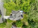 Aerial view of a beautiful home with a private backyard, pool and deck surrounded by lush trees at 2213 Normandin Ct, Charlotte, NC 28216