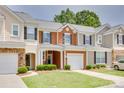 Charming townhome showcasing colorful siding, a one-car garage, and a beautifully maintained front lawn at 244 River Clay Rd, Fort Mill, SC 29708