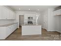 Bright kitchen boasts white cabinets, granite countertops, stainless appliances, and island with sink at 2712 Lehigh Rd, Charlotte, NC 28208