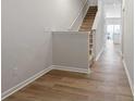 Bright hallway with hardwood floors leading to the kitchen, staircase on the left with carpeted steps at 2720 Lehigh Rd, Charlotte, NC 28208