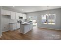 Eat-in kitchen with white cabinets, granite countertops, stainless steel appliances, and hardwood floors at 2720 Lehigh Rd, Charlotte, NC 28208
