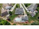 Aerial view of home featuring large inground pool, outdoor seating area, patio, well-manicured landscaping and mature trees at 2763 Rivendale Ct, Indian Land, SC 29707