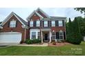 Stunning two-story brick home featuring a manicured lawn, mature trees, and classic architectural design at 2763 Rivendale Ct, Indian Land, SC 29707