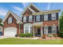 Traditional two-story brick home featuring black shutters, bay window, well-kept lawn, and an attached two-car garage at 2763 Rivendale Ct, Indian Land, SC 29707