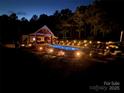 Inviting inground pool featuring lounge chairs, outdoor seating, landscape lighting, and a covered dining area at 2763 Rivendale Ct, Indian Land, SC 29707