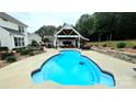Sparkling in-ground pool with an outdoor kitchen, dining, and lounge area, perfect for entertaining at 2763 Rivendale Ct, Indian Land, SC 29707