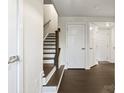 Hallway with wood floors, white trim, and staircase with wooden banister at 3003 Salix Bend Dr, Charlotte, NC 28205
