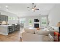 Bright, open-concept living room with fireplace, fan, and seamless flow to kitchen at 5723 Notch Peak Ave, Indian Land, SC 29707